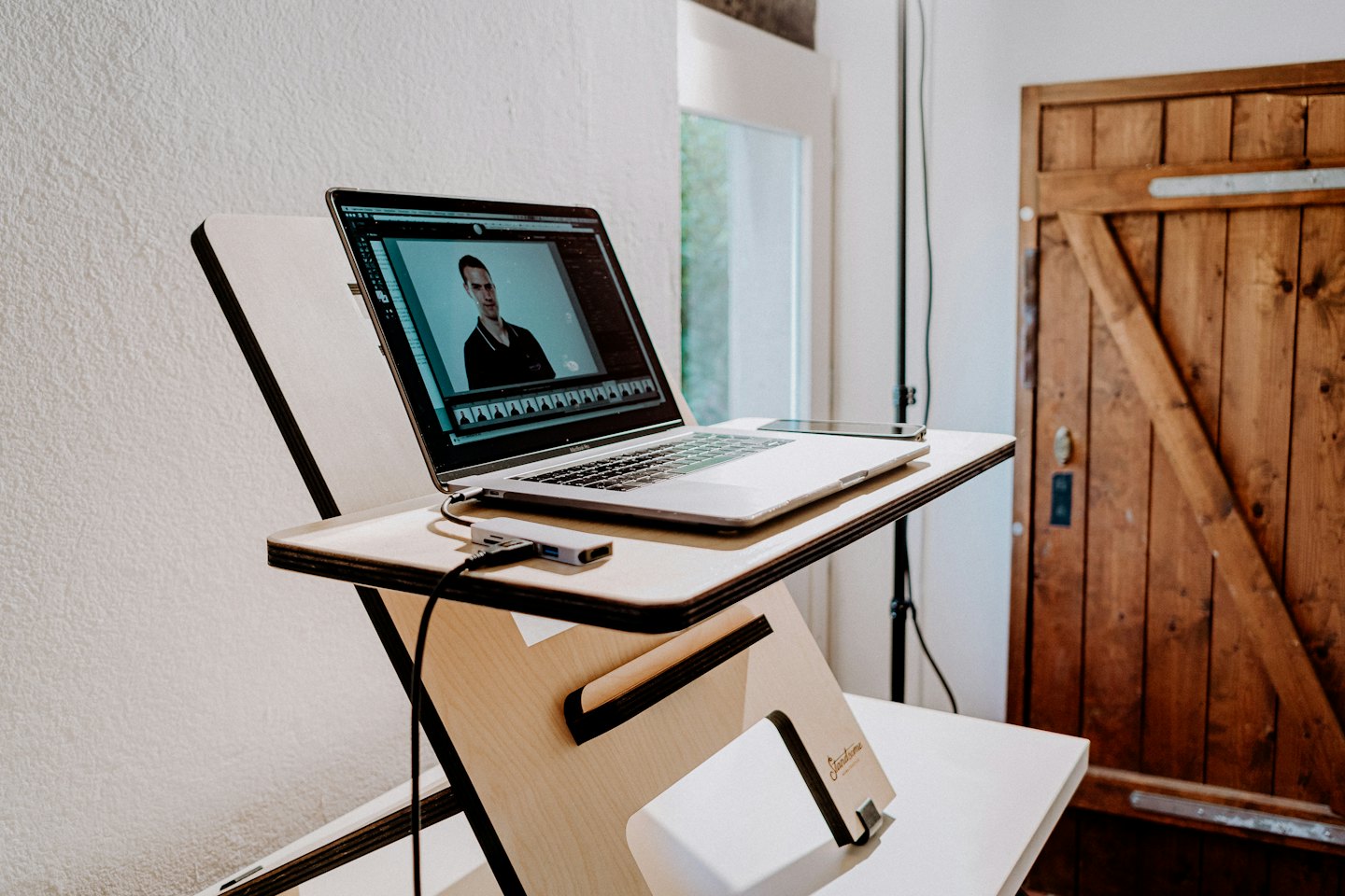 Laptop on standing desk showing editing software.