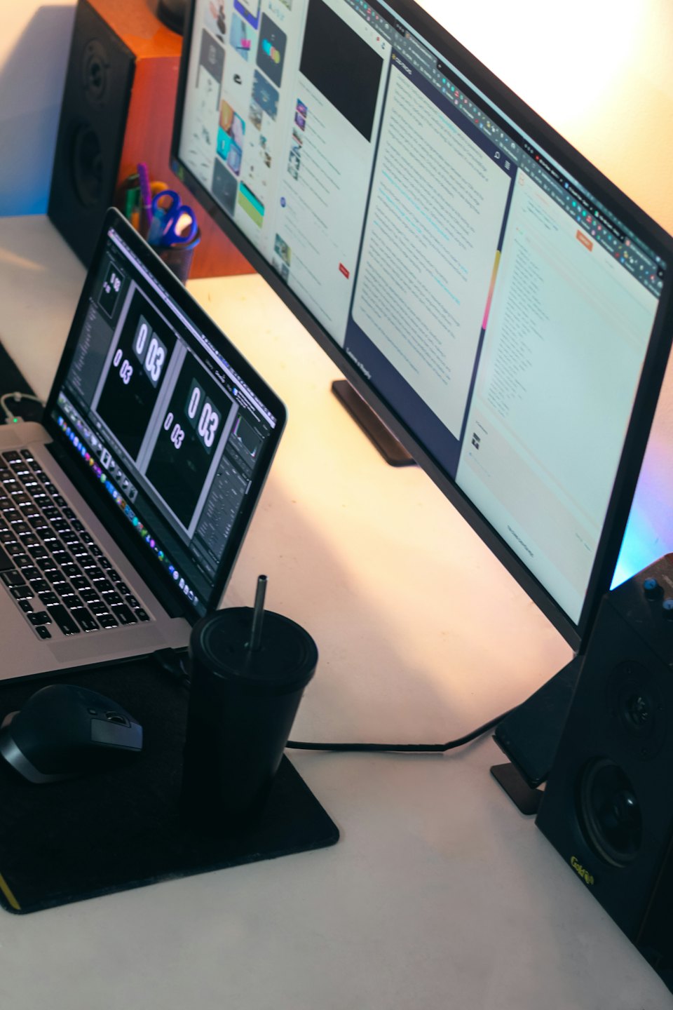 Laptop and monitor display software on a white desk.