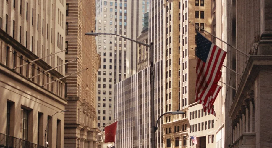 Wall Street in New York City's financial district with American flags